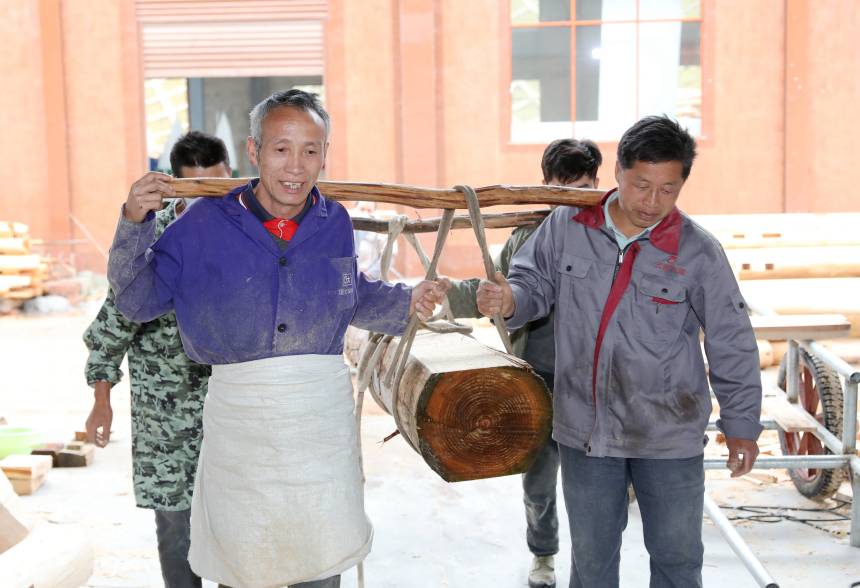 幾名侗族工匠在抬運木料。龔普康攝