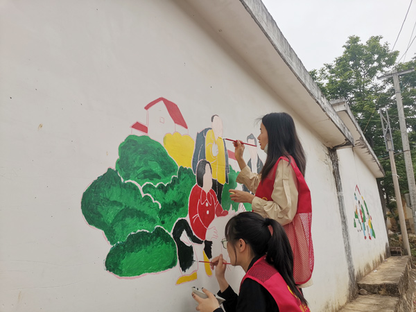 青年志愿者在绘制文化墙。