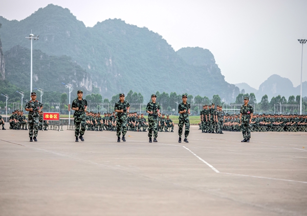 新训官兵正在进行跑步行进与立定课目会操。