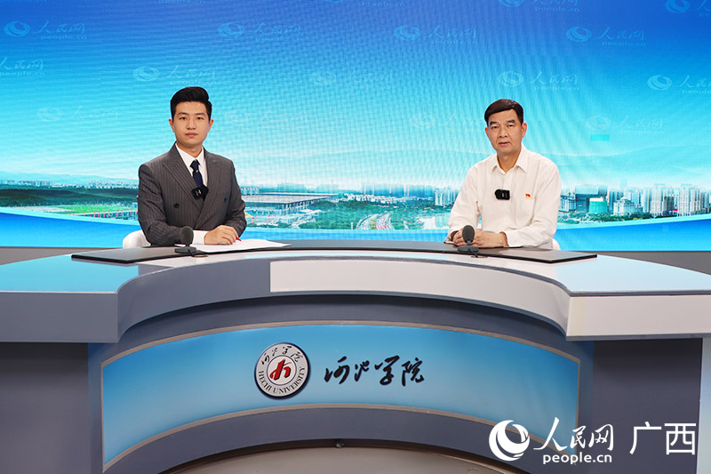 河池学院党委书记韦安光（右）接受人民网专访。人民网 覃心摄