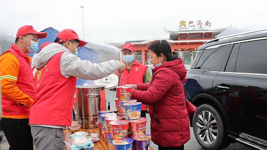 图为志愿者为返乡旅客提供泡面