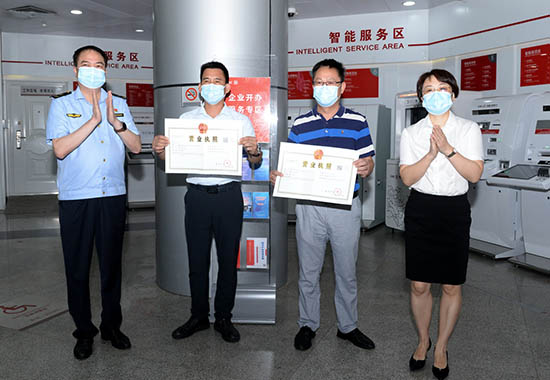 照片5：北海市市场监督管理局沈祖亮局长、工商银行北海分行刘敏行长为企业客户颁发营业执照。