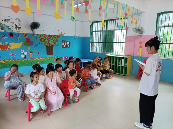 广西科技师范学院学生到忻城县六纳村向当地儿童推广普通话。莫文华摄