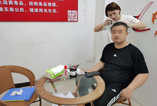社工对社区戒毒（康复）人员进行毛发检测。兴安县公安局供图