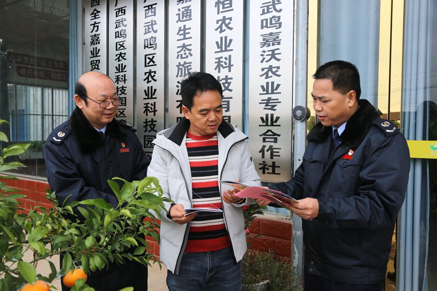 图为南宁市武鸣区税务局服务团队下农企宣传税惠政策。