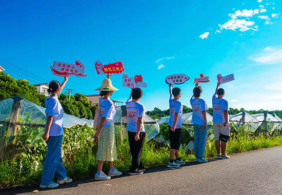 实践团成员在毛竹山村田间拍摄宣传海报。黄杰国摄