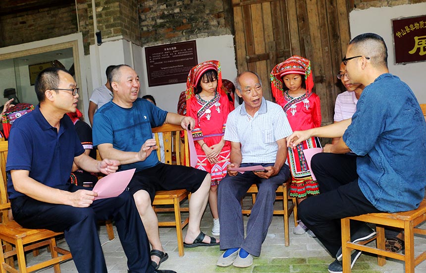 钟山县文旅局党员干部向两安瑶族乡群众宣传清廉文化。廖超文摄