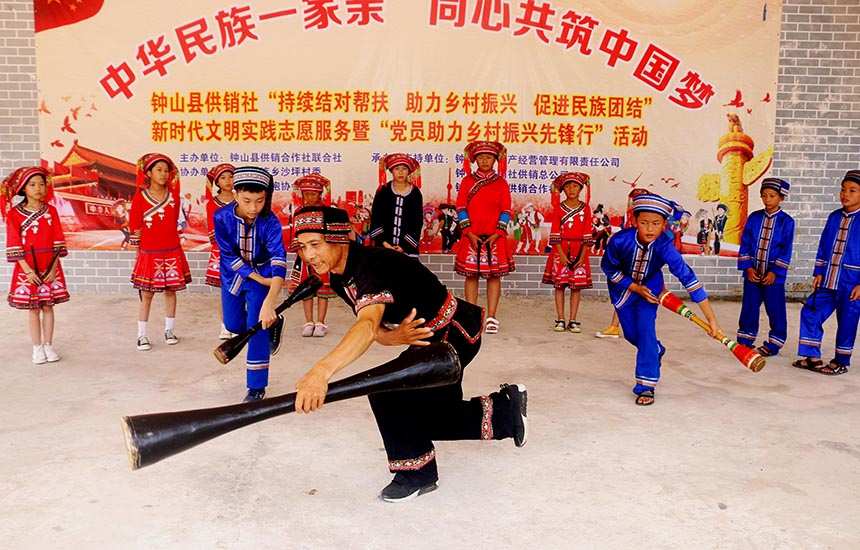 两安瑶族乡“非遗”传承人向孩子们传授羊角长鼓舞动作要领。廖超文摄