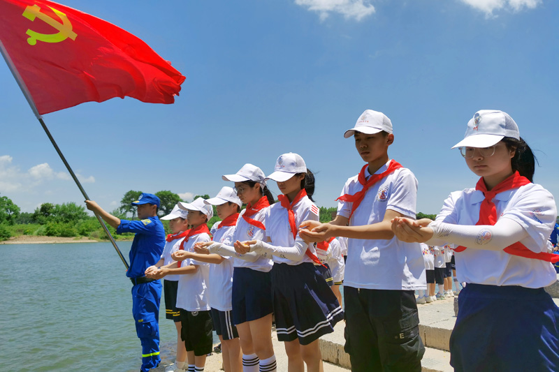 红领巾讲解员在大屏渡口祭奠英魂。全州县委组织部供图
