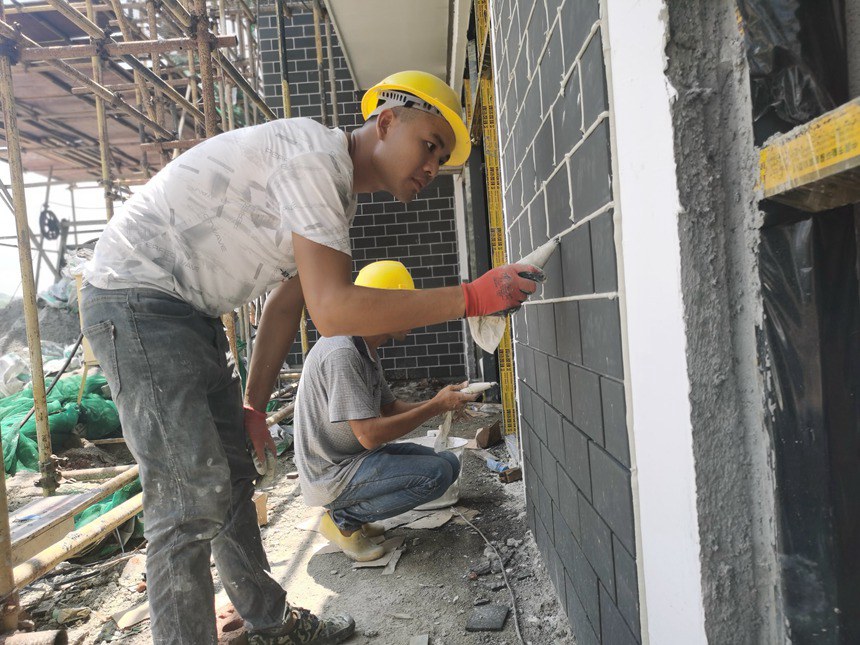 在宁明县乡村振兴创业街项目建设工地，工人们正顶着烈日进行装修作业