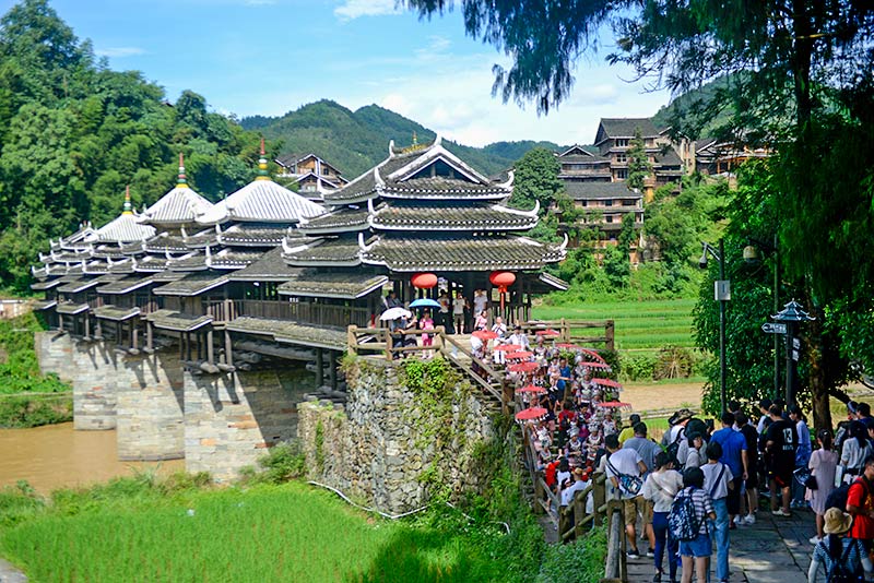 侗乡群众在城阳风雨桥前迎接八方游客。三江县委统战部供图