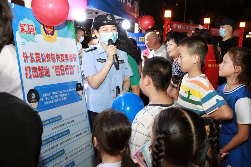 8月22日晚，河池公安民警正在夏季治安打击整治“百日行动”警企宣防活动现场给现场群众讲解。张振刚摄