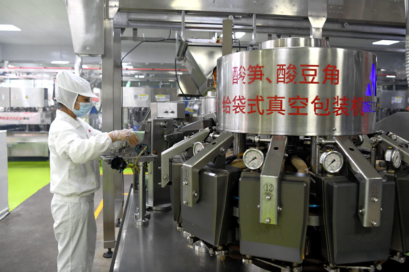 工人们正在螺蛳粉生产线上工作。