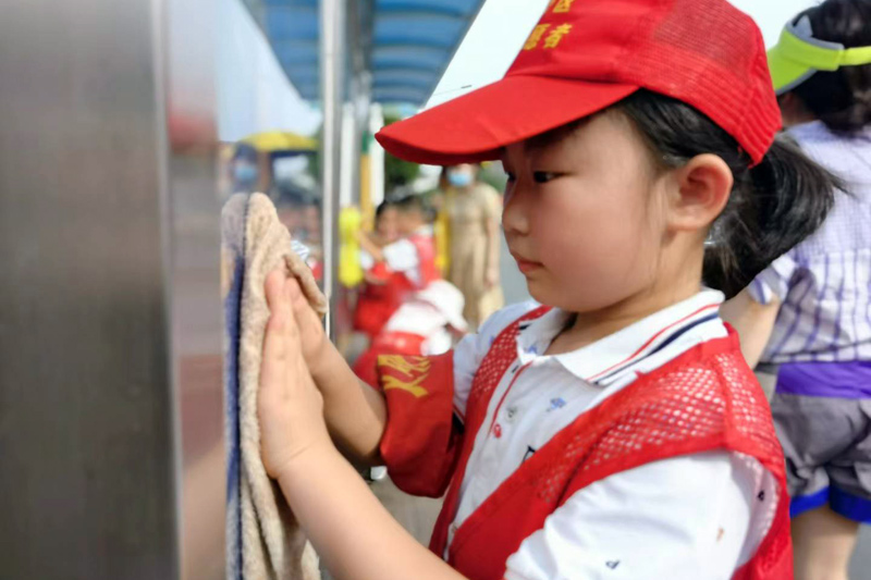 農欣蕊戴上愛心小紅帽，做起了小小志願者。西鄉塘區教育局供圖