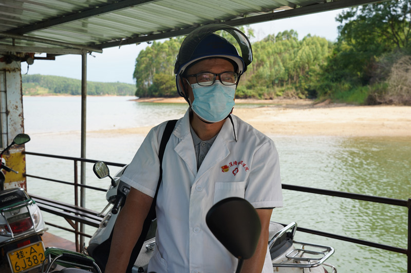 卢家恒医生一如往常坐渡船横过郁江前往村民家中服务。