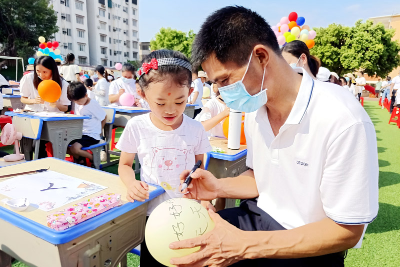 家長和小孩子在氫氣球上寫下心願。