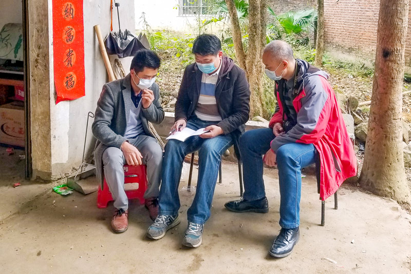 广西梧州市烟草专卖局乡村振兴驻点工作队员汪松青入户宣传法律法规。