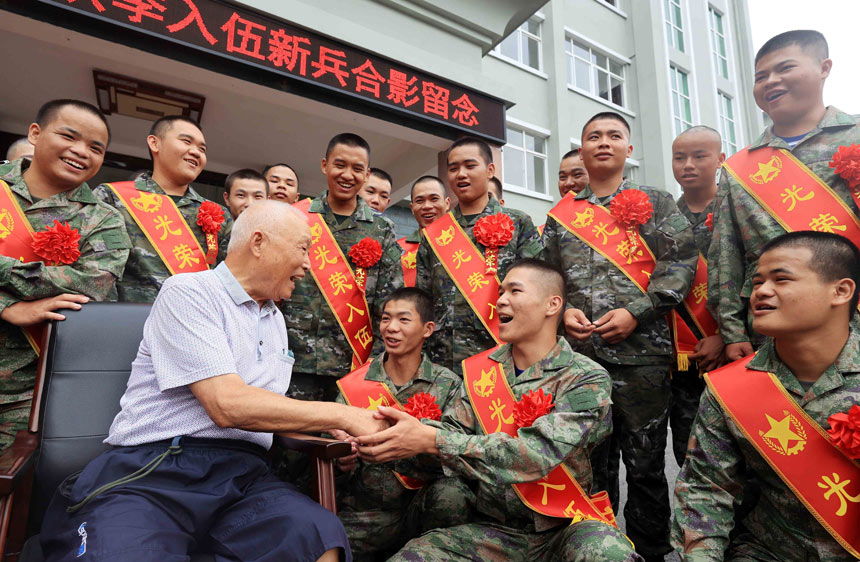 黄定邦老先生鼓励应征青年发扬男儿本色，刻苦训练。
