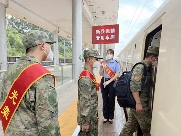 “刘三姐·金花茶”服务队成员在一旁引导新兵战士进车厢。李天成摄