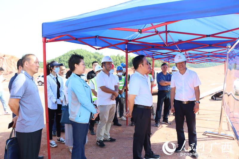 唐宁（前排右二）在广西飞碟靶场训练比赛基地项目工地了解工程进展。人民网 付华周摄
