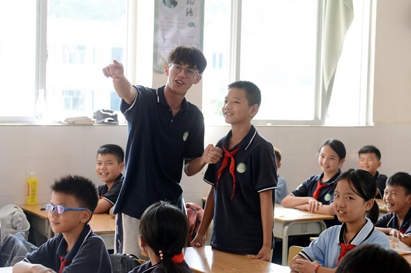 覃珍锡指导学生吟诵古诗。广西教育出版社供图