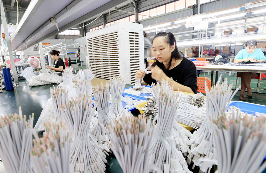 在廣西柳州市融安縣粵桂協作產業園一家電子廠生產車間，工人們正在生產數據線。