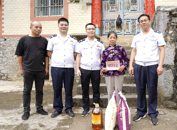 东兰县税务局党员干部为受灾群众送上粮油和慰问金。韦东江摄