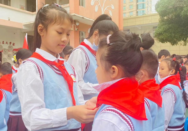 少先队员为新队员佩戴红领巾。百色市右江区实验小学供图