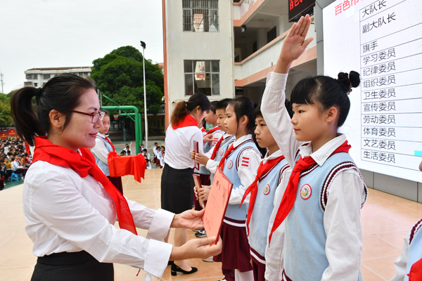 为新一届少先队大队委颁发聘书并授臂章。百色市右江区实验小学供图