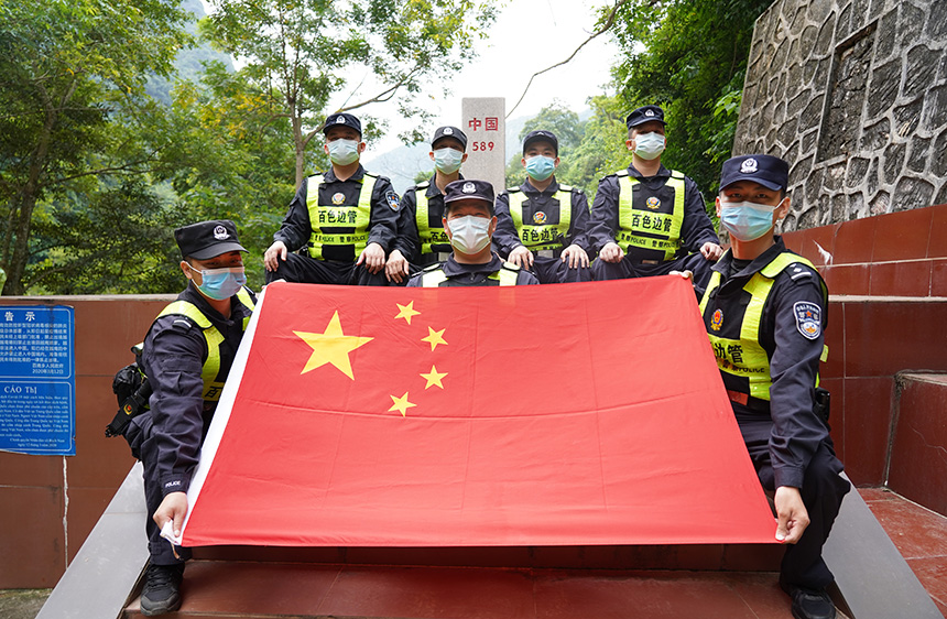 戍边民警在界碑前展示国旗。胡渝黔摄