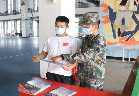 现场工作人员发放征兵宣传手册并为大学生解答疑惑。张清安摄