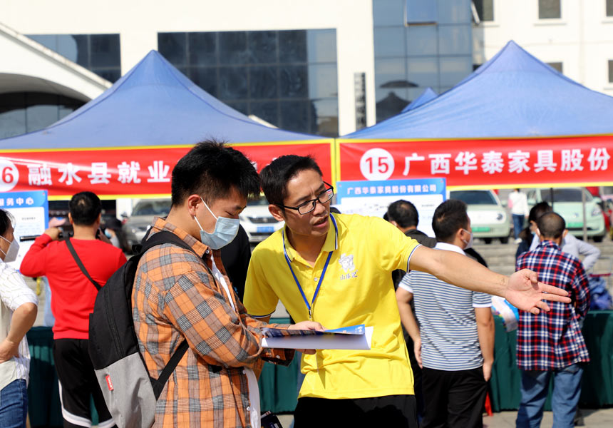 企業工作人員在給求職者介紹崗位信息。