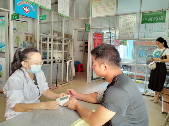 灵山县那隆镇新田村卫生室为居民开展健康检查服务。