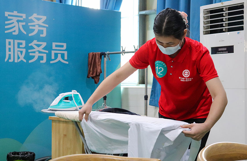 家务服务员在熨烫衬衫。徐家亮摄