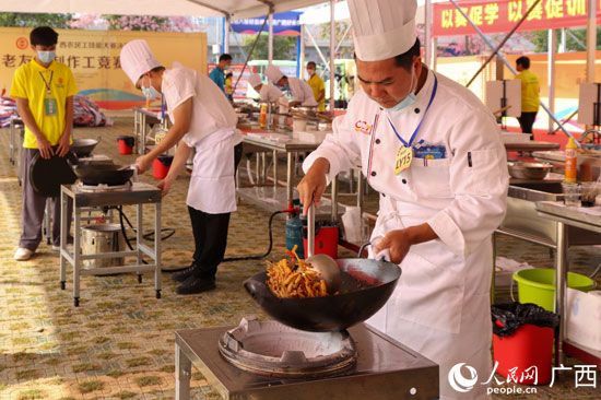 在老友粉制作工竞赛现场，参赛选手在娴熟地烹饪美食。.jpg