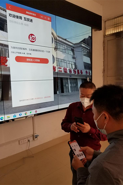 边民代表在手机上操作“互贸通” 微信小程序进行互市商品交易。广西商务厅供图