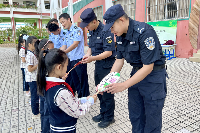 西乡塘小学学生代表将亲手绘制的清廉扇送给民警叔叔们。学校供图