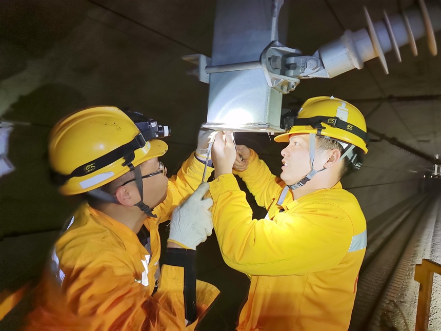 接触网工正在对南广线隧道吊柱进行检修。郭凡摄