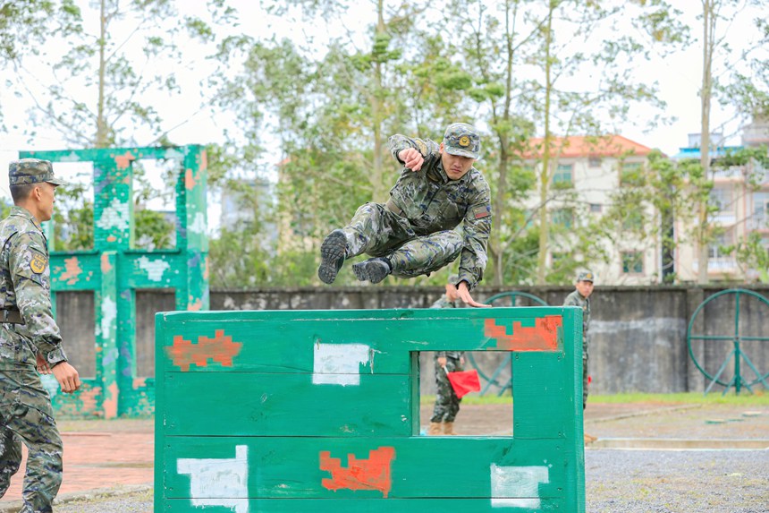 参赛官兵飞跃矮墙。