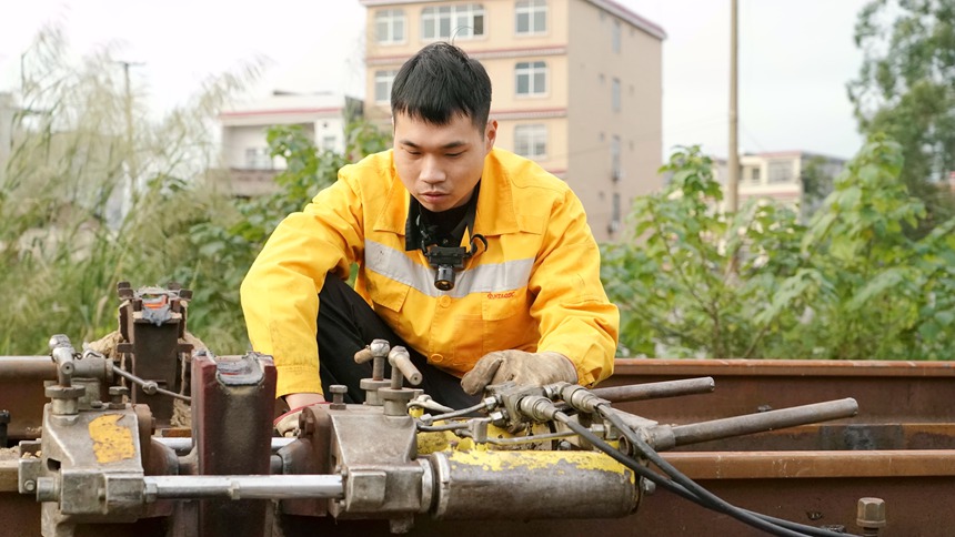 玉林工务段职工利用钢轨拉力压缩机对焊缝接头进行推镏作业。谭育俊摄