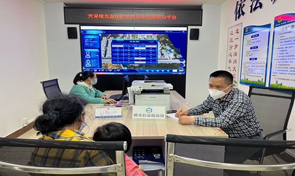 天等县龙岩社区工作人员利用网格化系统处置群众反馈问题。