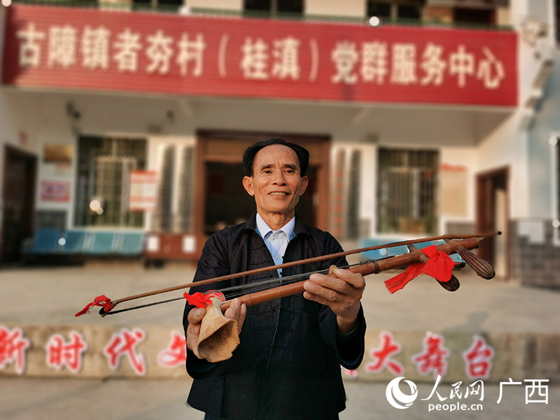 八音团成员展示具有70多年历史的马骨胡。人民网 付华周摄