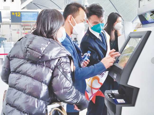 旅客在机场人员指导下自助办理值机。记者 苏昭宇摄