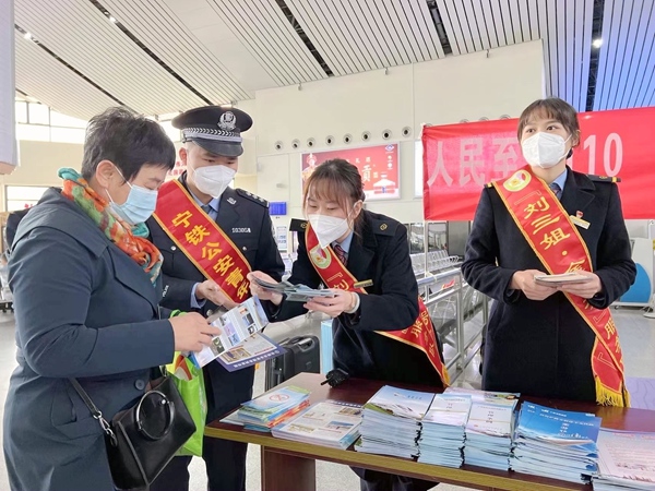 防城港北站客运员和铁路公安一起发放宣传手册。李天成摄