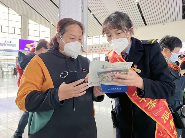 防城港北站客运值班员郑琦川和旅客讲解安全知识。李天成摄