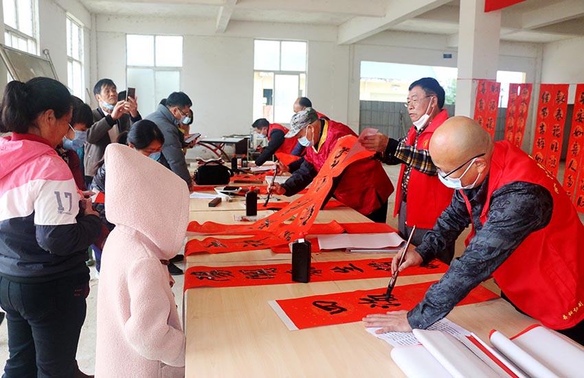 志愿者在公安镇安置小区开展送春联活动。廖超文摄