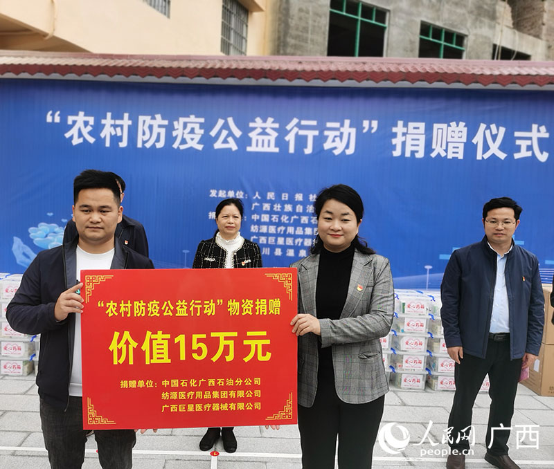 人民网广西频道代表捐赠单位向陆川县温泉镇洞心村捐赠防疫物资。人民网 付华周摄