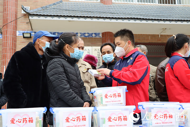 工作人員向村民介紹愛心藥箱。人民網 付華周攝