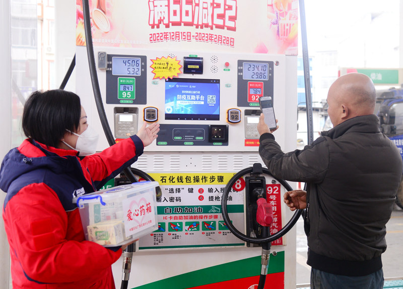 中国石化广西石油加油站员工指导司机使用人民网“防疫互助平台”。中国石化广西石油供图