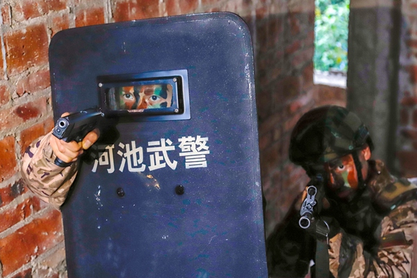 武警官兵在废弃楼房搜索围剿目标。
